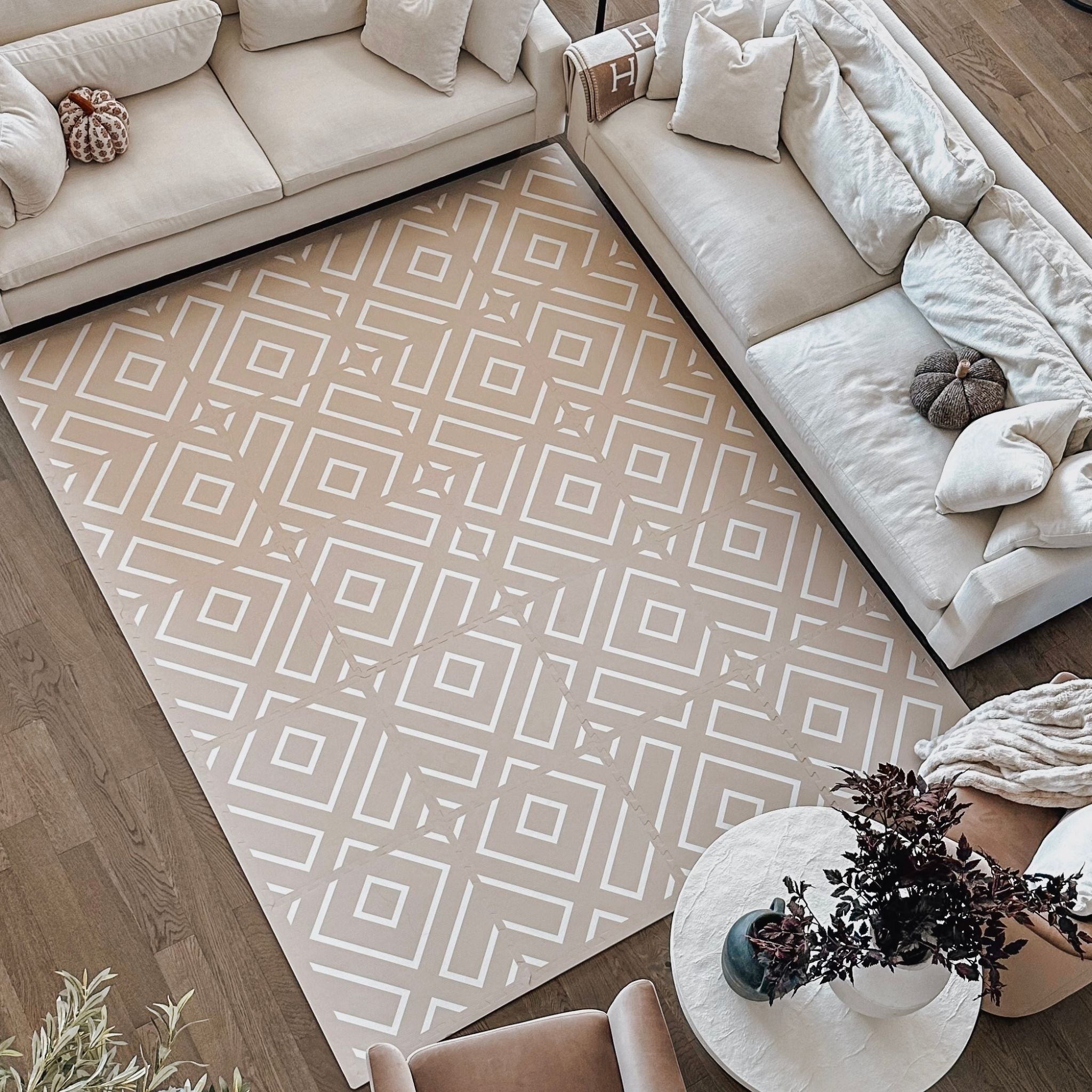 Grand tapis de jeu à motif dans un salon clair, devant le canapé
